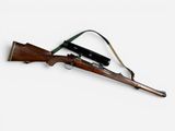 an old rifle with a sling attached to it on a white surface