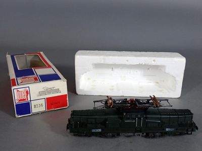un petit train en jouet posé à côté d'un paquet de cigarettes