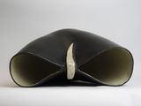 a close up of a black vase on a white surface