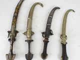 four different types of knives are lined up on a white surface