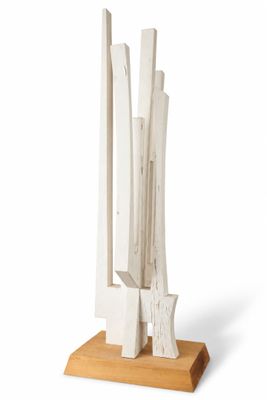 a white sculpture on a wooden base on a white background