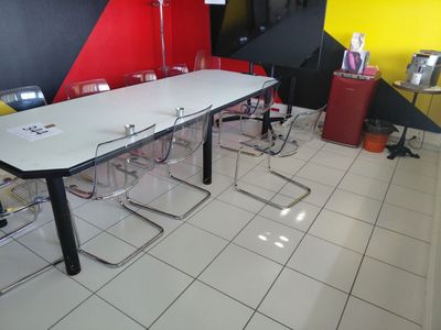 a white table and chairs in a room with a yellow wall