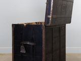 a black trunk sitting on the floor in a room