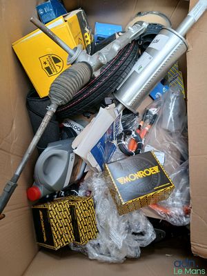 une boîte en carton remplie d'objets divers, dont un aspirateur