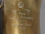 a brass vase with a label on it