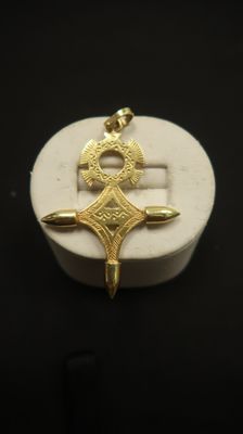 un gros plan d'une petite boîte blanche ornée d'une croix dorée
