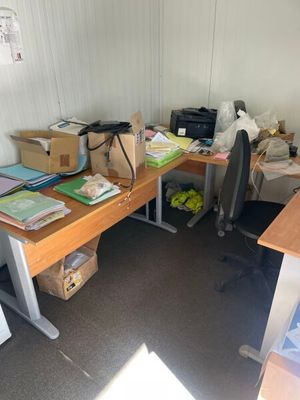 un bureau sur lequel se trouvent un ordinateur, une imprimante et d'autres objets