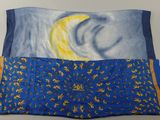 a picture of a blue and yellow pillow with a picture of the moon on it