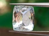 une pierre de cristal transparente maintenue par une pince
