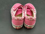 pair of pink and white checkered slip - ons on a black surface