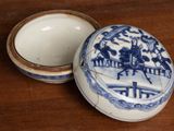 a small blue and white box with a lid on a table