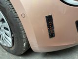 a close up of a pink car with a sticker on it