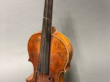 an old violin sitting on top of a table next to a wall