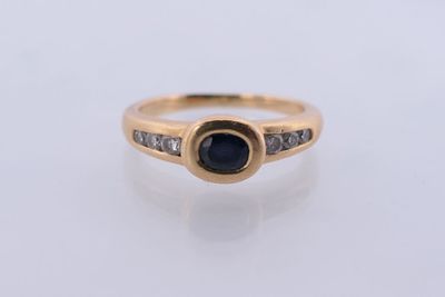 une bague en or jaune sertie d'un saphir et de diamants