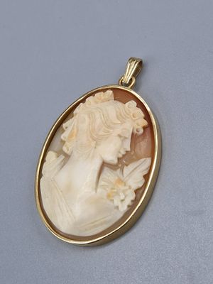 un gros plan d'un pendentif représentant le visage d'une femme