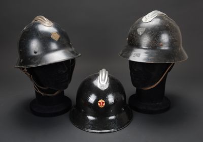 trois casques sont empilés les uns sur les autres sur une surface noire
