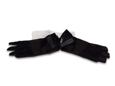 une paire de gants noirs posée sur une surface blanche, avec un ruban noir