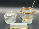 a glass ice bucket with a gold handle next to a glass ice bucket with a gold handle next to a glass ice bucket with a gold handle