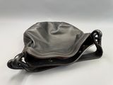 the small black bag is sitting on a white surface