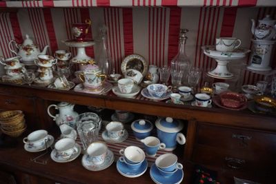 de nombreuses tasses et soucoupes posées sur une étagère en bois