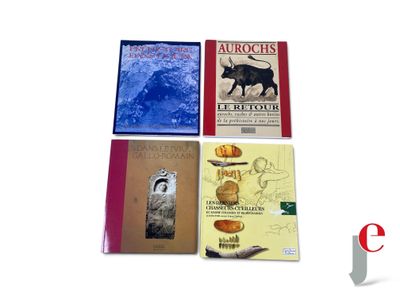 several books are sitting on a white surface with a red cover