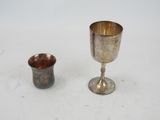 a silver goblet and a silver cup on a table