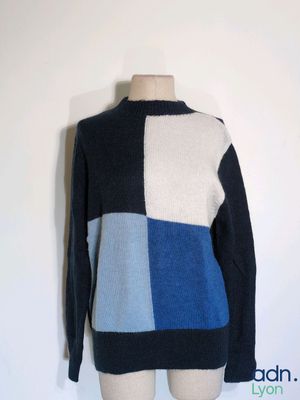 the sweater is blue, white, and black with a patchwork design