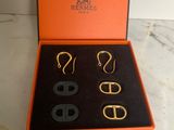 an orange box with three pairs of earrings and a pair of scissors