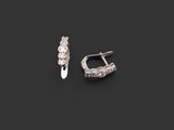 a pair of silver earrings on a black background