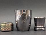 three silver vases sitting next to each other on a table