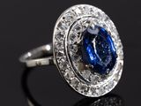 an image of a sapphire and diamond ring on a black surface