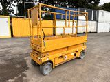 the yellow scissor is parked in the parking lot next to some containers