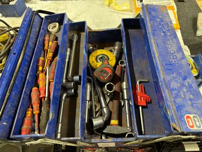 de nombreux outils dans une boîte bleue posée sur une table