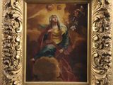 un tableau représentant une femme assise sur un rocher, dans un cadre doré