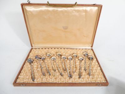 six silver spoons in a case on a white surface