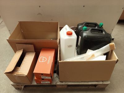 un carton rempli de récipients de toutes sortes et des récipients éparpillés par terre