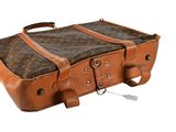 a brown and black suitcase sitting on top of a white surface