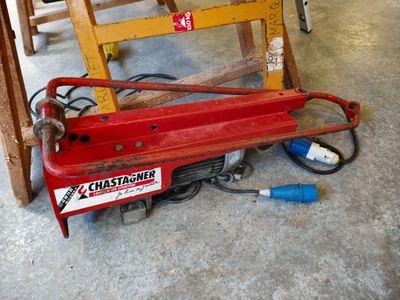 a red machine that is sitting on the floor next to a chair