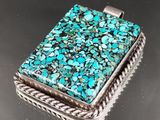 un pendentif carré en pierre turquoise, monté sur un cadre en corde
