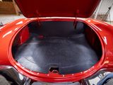 a red car with its trunk open in a garage