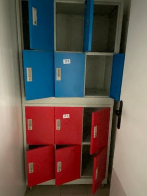a red and blue locker in the corner of a room