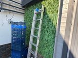 une échelle appuyée contre le mur, à côté d'un immeuble