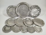 several silver plates and trays sitting on a white surface