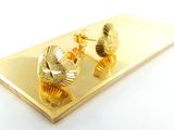 une photo d'une paire de boucles d'oreilles posées sur une assiette en or