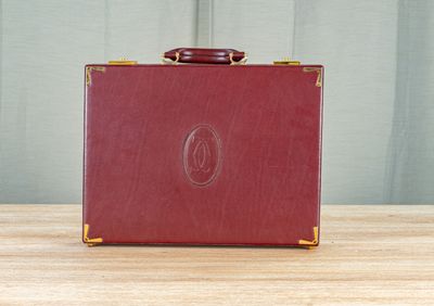 une valise rouge posée sur une table en bois