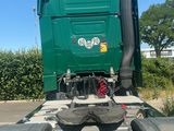 a green dump truck that is driving down the road