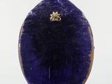 an image of a purple stone with a gold bee on it