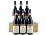 three bottles of red wine sit on a wooden crate