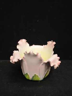 un vase blanc contenant des fleurs roses, sur fond noir