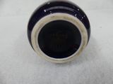 a close up of a blue vase on a white surface